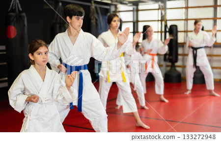 Group of children and teenagers practice karate Group of children and teenagers practice karate 133272948