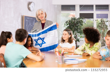 Mature woman teacher tells pupils the history of Israel Mature woman teacher tells pupils the history of Israel 133272955