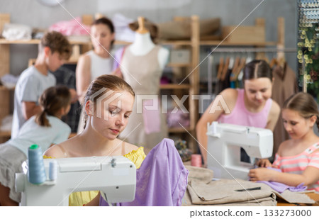 Proud teenage girl showing sewing work in clothing course Proud teenage girl showing sewing work in clothing course 133273000