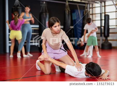 Teenage girl sparring with boy during training Teenage girl sparring with boy during training 133273013