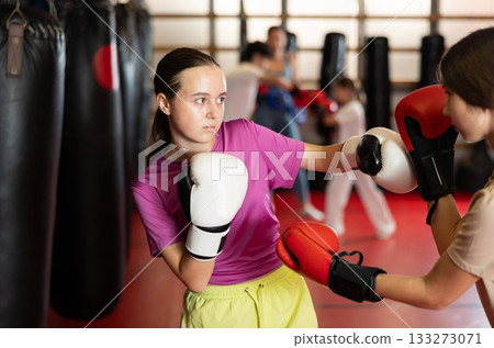 Teen girls in boxing gloves sparring 133273071