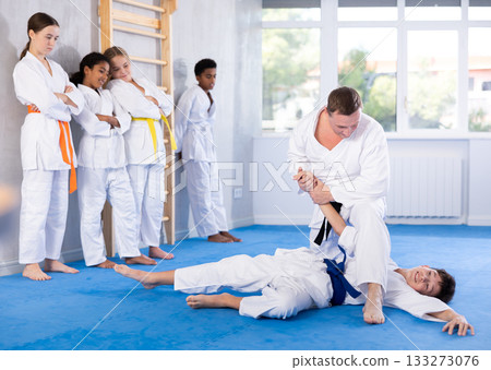Judo master demonstrating armbar technique in sparring with student Judo master demonstrating armbar technique in sparring with student 133273076