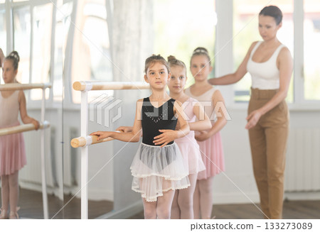 Girls in ballet class perform first position with correction of female mentor Girls in ballet class perform first position with correction of female mentor 133273089