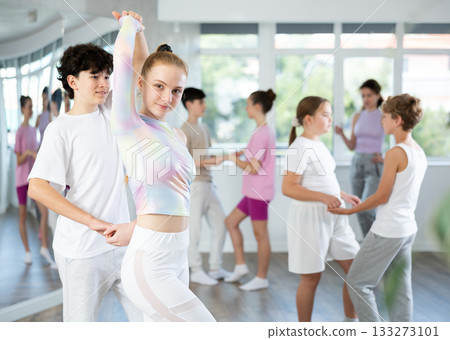 Girl dances Latin dance with male boy teen partner during choreography lesson 133273101