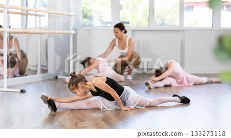 Little girls ballerinas learn to do the splits in dance class 133273118