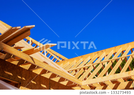 Construction of wooden roof frame under trusses studs at building site 133273493
