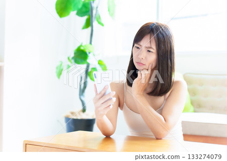 女子使用智慧型手機,檢查皮膚,皮膚粗糙 女子使用智慧型手機,檢查皮膚,皮膚粗糙 133274079