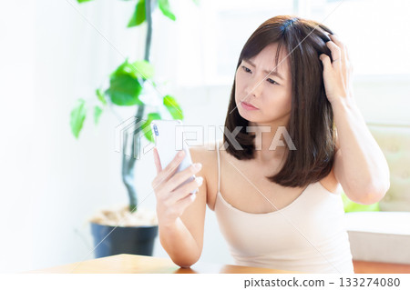 Woman using smartphone, skin check, rough skin 133274080