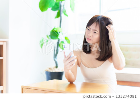 Woman using smartphone, skin check, rough skin 133274081