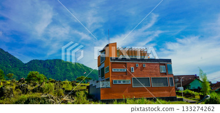 beautiful view of a village at the foot of a hill covered in mist 133274262