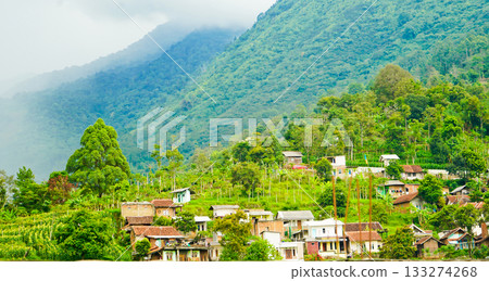 beautiful view of a village at the foot of a hill covered in mist 133274268