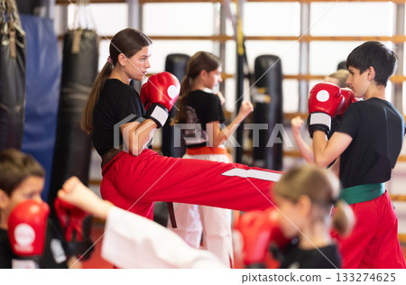 Group of children and teenagers train with boxing gloves 133274625