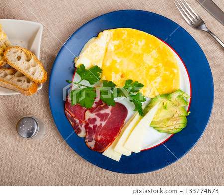 Omelet with avocado, jamon and cheese on a plate Omelet with avocado, jamon and cheese on a plate 133274673