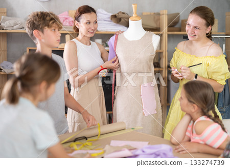 Sewing teacher demonstrates dressmaking to school kids Sewing teacher demonstrates dressmaking to school kids 133274739