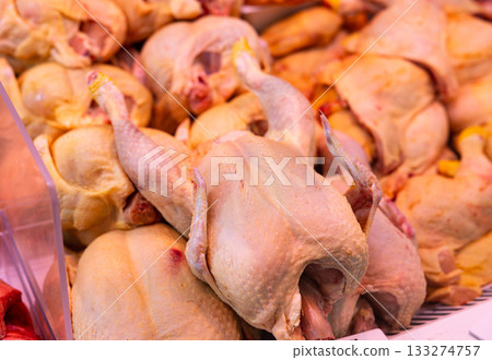 Refrigerated display case contains whole chilled chicken carcasses 133274757