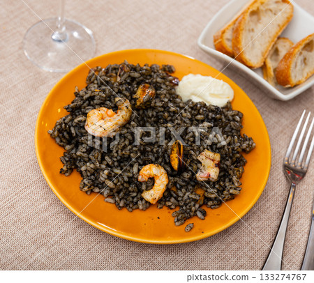 Paella is variant of dish made from black rice and seafood Paella is variant of dish made from black rice and seafood 133274767