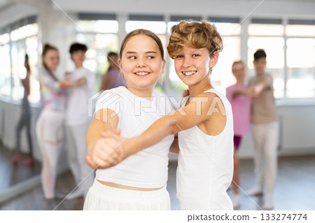 Girl dances waltz with male boy teen partner during choreography lesson 133274774