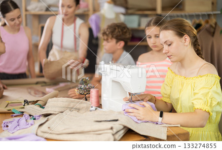 Girl child watches female classmates sew and creating clothes 133274855