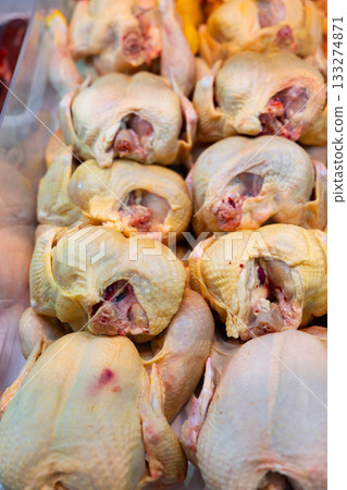 Refrigerated display case contains whole chilled chicken carcasses 133274871