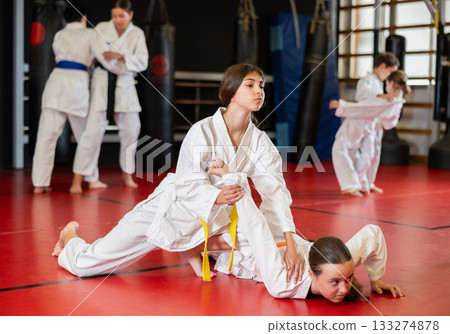 Children athletes in pair conduct training battle in oriental fighting technique Children athletes in pair conduct training battle in oriental fighting technique 133274878