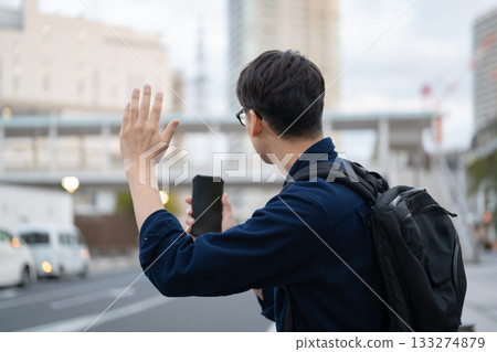 一名男子在街上舉起手 133274879
