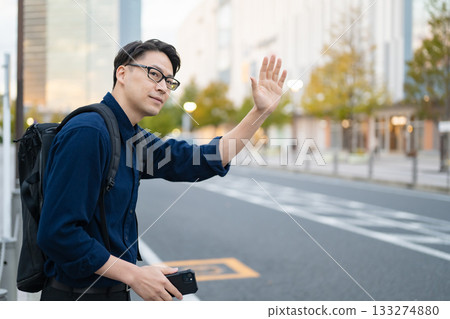 Man raising his hand on the street Man raising his hand on the street 133274880
