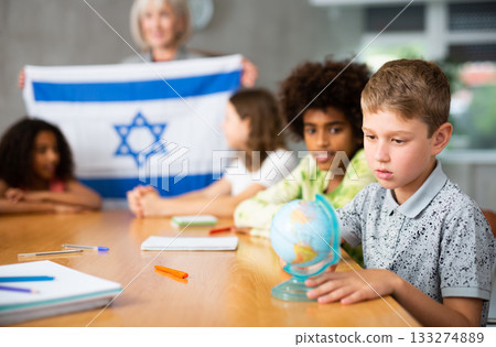 students listen to teacher who talks about Israel 133274889