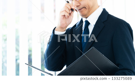 Businessman thinking by the window Businessman thinking by the window 133275089