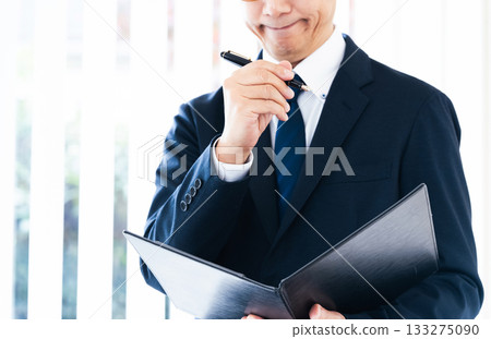 Businessman thinking by the window Businessman thinking by the window 133275090
