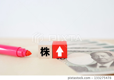 Image of the Japanese yen and an upward arrow indicating rising stock prices. 133275478