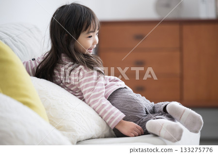 Relaxing scene of a smiling girl relaxing on the sofa 133275776