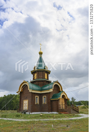 Wooden church with gilded dome and cross in the village of Lokti, Siberia, Russia, in summer 133275820