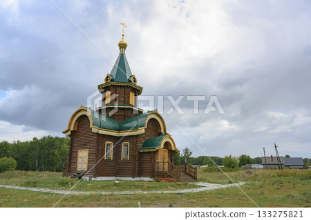 Wooden church with gilded dome and cross in the village of Lokti, Siberia, Russia, in summer 133275821