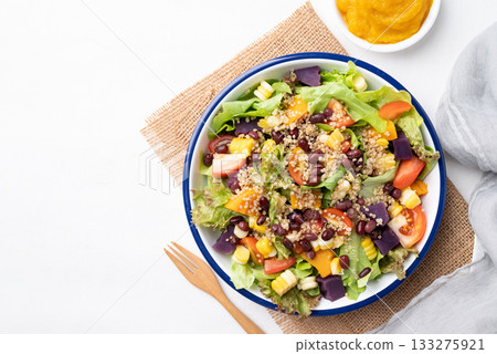 Healthy vegetable salad bowl and pumpkin dressing on white background. Vegan and plant-based food Healthy vegetable salad bowl and pumpkin dressing on white background. Vegan and plant-based food 133275921