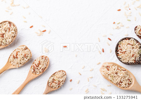 Thai brown rice seed (Highland wild rice) in difference wooden spoon on white background, Top view 133275941