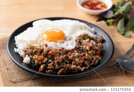 Thai food, Stir fried holy basil with minced pork with cooked rice and fried egg on top Thai food, Stir fried holy basil with minced pork with cooked rice and fried egg on top 133275958