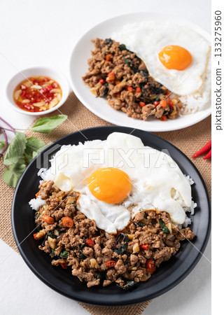 Thai food, Stir fried holy basil with minced pork with cooked rice and fried egg on top Thai food, Stir fried holy basil with minced pork with cooked rice and fried egg on top 133275960