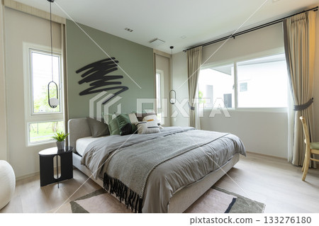 Modern bedroom interior with green wall and wall art with hanging lamp. 133276180
