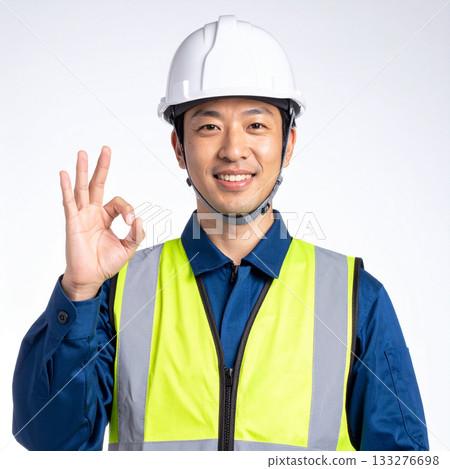 A field worker wearing a safety vest makes an OK pose 133276698
