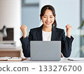 A career woman pumping her fist in the office 133276700