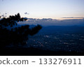 A night view of the cityscape, mountains, and tree silhouettes at dusk 133276911