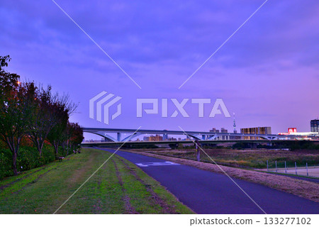 從荒川河岸眺望夜色下的捨人號列車和荻大橋 133277102