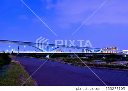 從荒川河岸眺望夜色下的捨人號列車和荻大橋 133277105