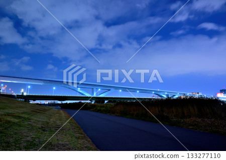 Night view of the Toneri Liner and Ogi Ohashi Bridge from the Arakawa River bank 133277110