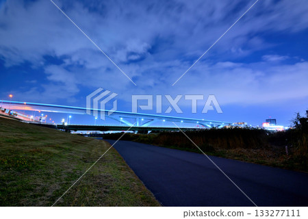 Night view of the Toneri Liner and Ogi Ohashi Bridge from the Arakawa River bank 133277111