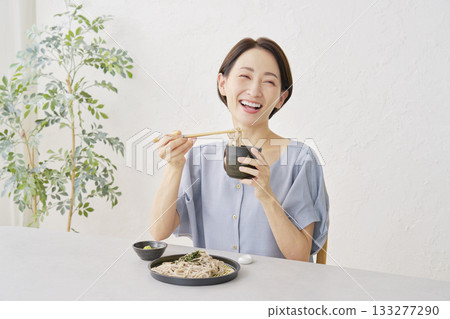 A woman eating cold soba noodles in the living room A woman eating cold soba noodles in the living room 133277290