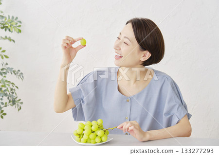 A woman eating Shine Muscat grapes in the living room 133277293