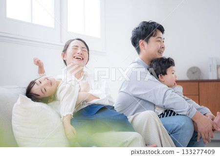 一家人窩在沙發上歡笑,幸福的時光。 一家人窩在沙發上歡笑,幸福的時光。 133277409