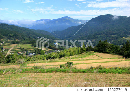 Scenery of a mountain village with terraced rice fields after the rice harvest 133277449