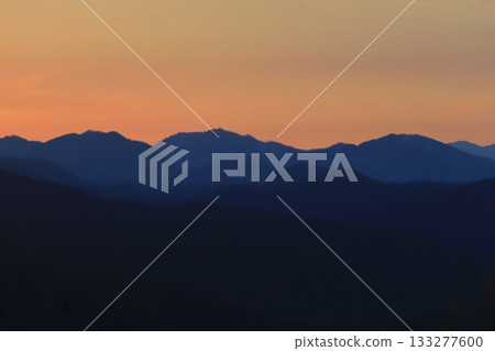 北海道鄉村景色：夕陽下的山巒染成紅色。 133277600